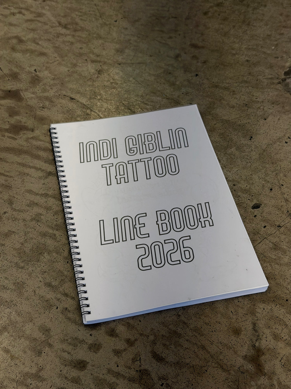 Front cover of Indi Giblin’s 2026 Line Book, photographed on a concrete floor.