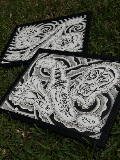Angled view of two framed Indi Giblin flash sheets, showing the eagle, dagger and mask composition in the foreground.